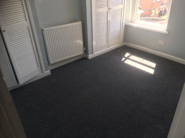 Double bedroom with window, radiator and fitted wardrobe doors