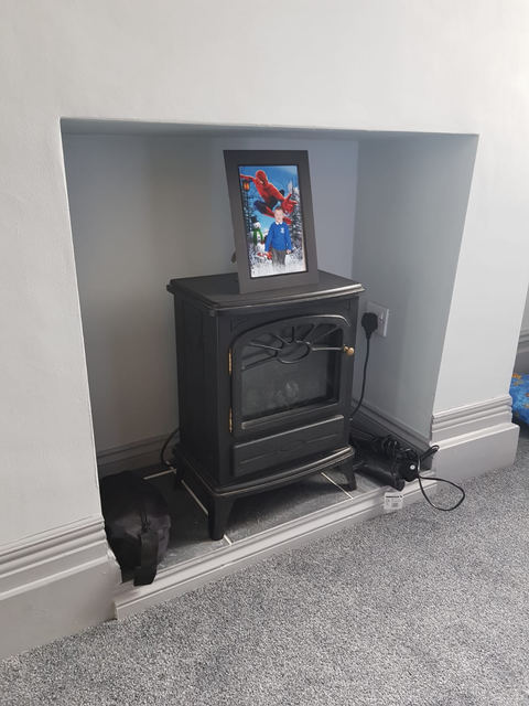 Electric stove set into the chimney breast of the living room