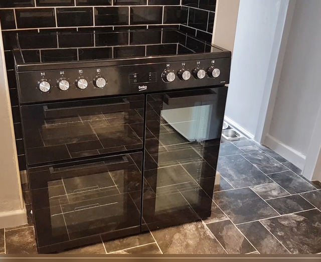 Range cooker with black tiled splashback in the kitchen